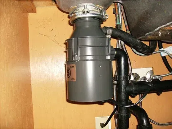 Garbage disposal under a kitchen sink.