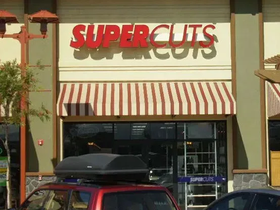 Supercuts storefront with red and white striped awning, red sign.