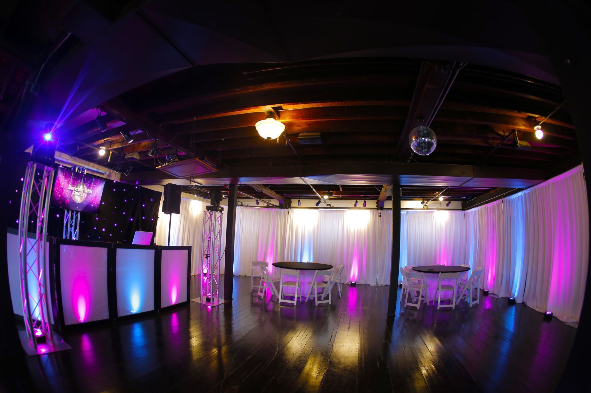 Harvard Boat Club room with Lit Tables, uplighting, Pipe and Drape chairs and a dj booth with Fiber Optic Backdrop and LED 65