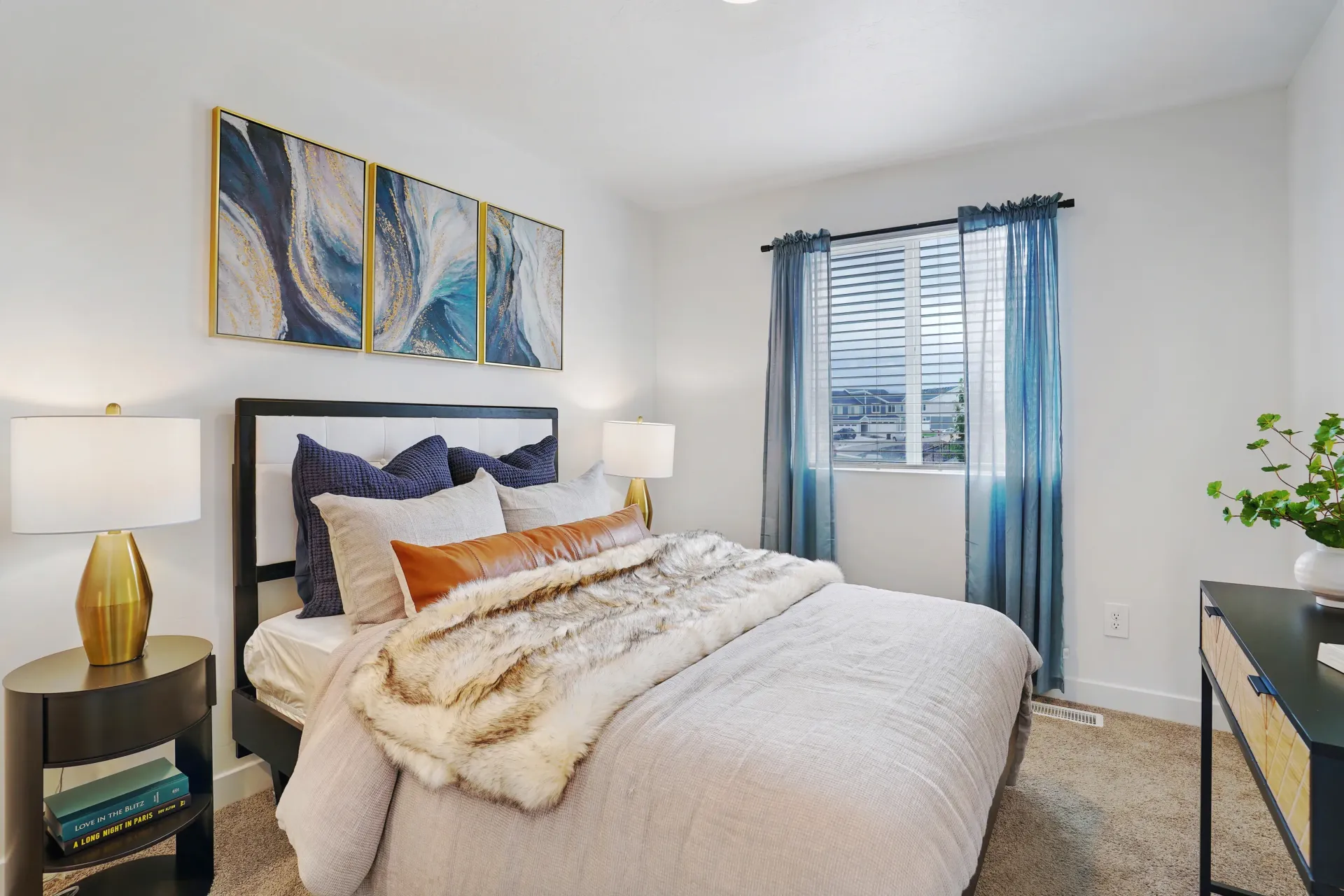 Bedroom with a king-size bed, side tables, and abstract wall art at Little Valley, offering pet-friendly apartments in Magna, UT.