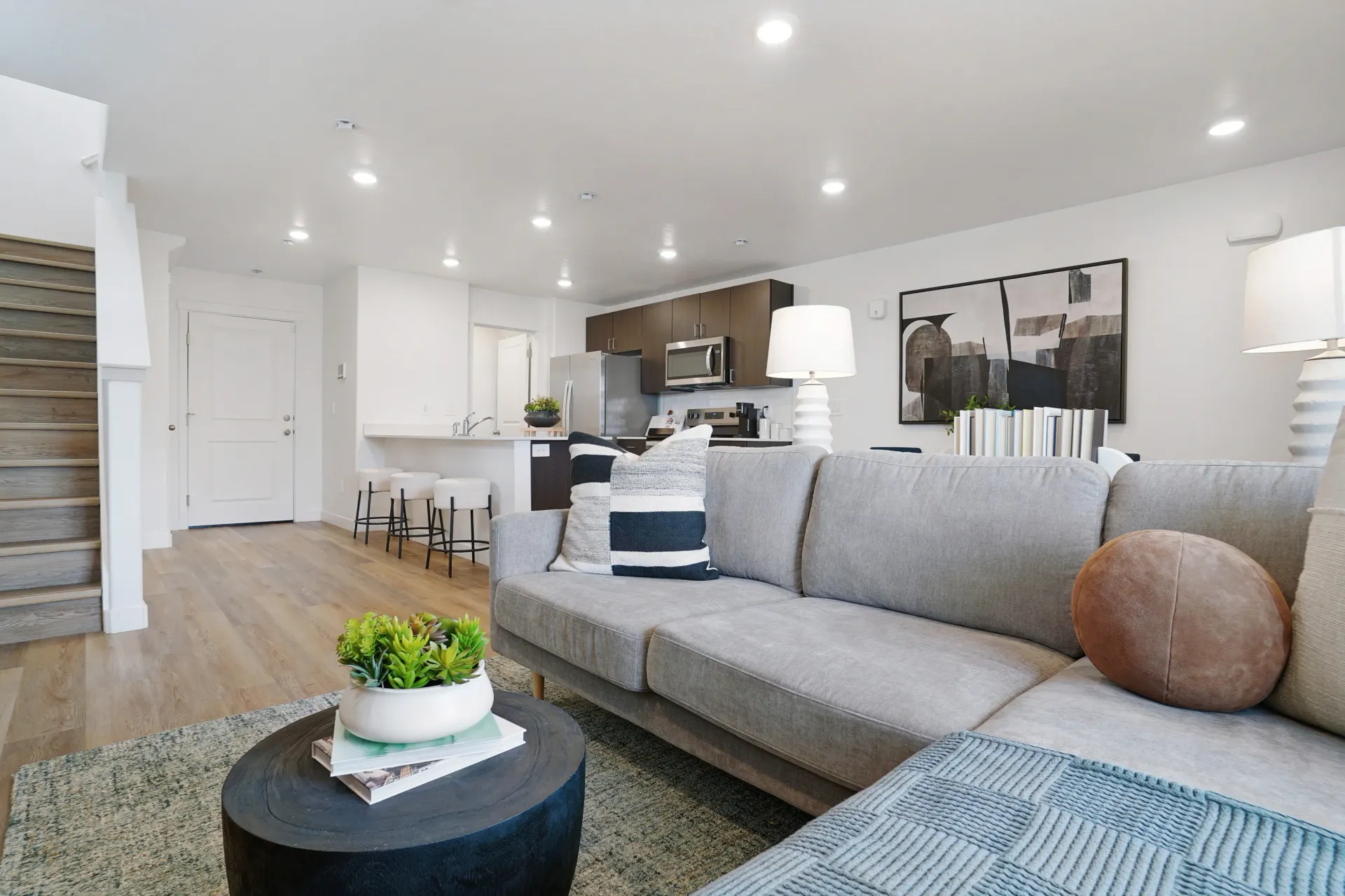 Living room and kitchen area of a luxury apartment with stairs on the side at Little Valley, offering apartments for rent in Magna, UT.