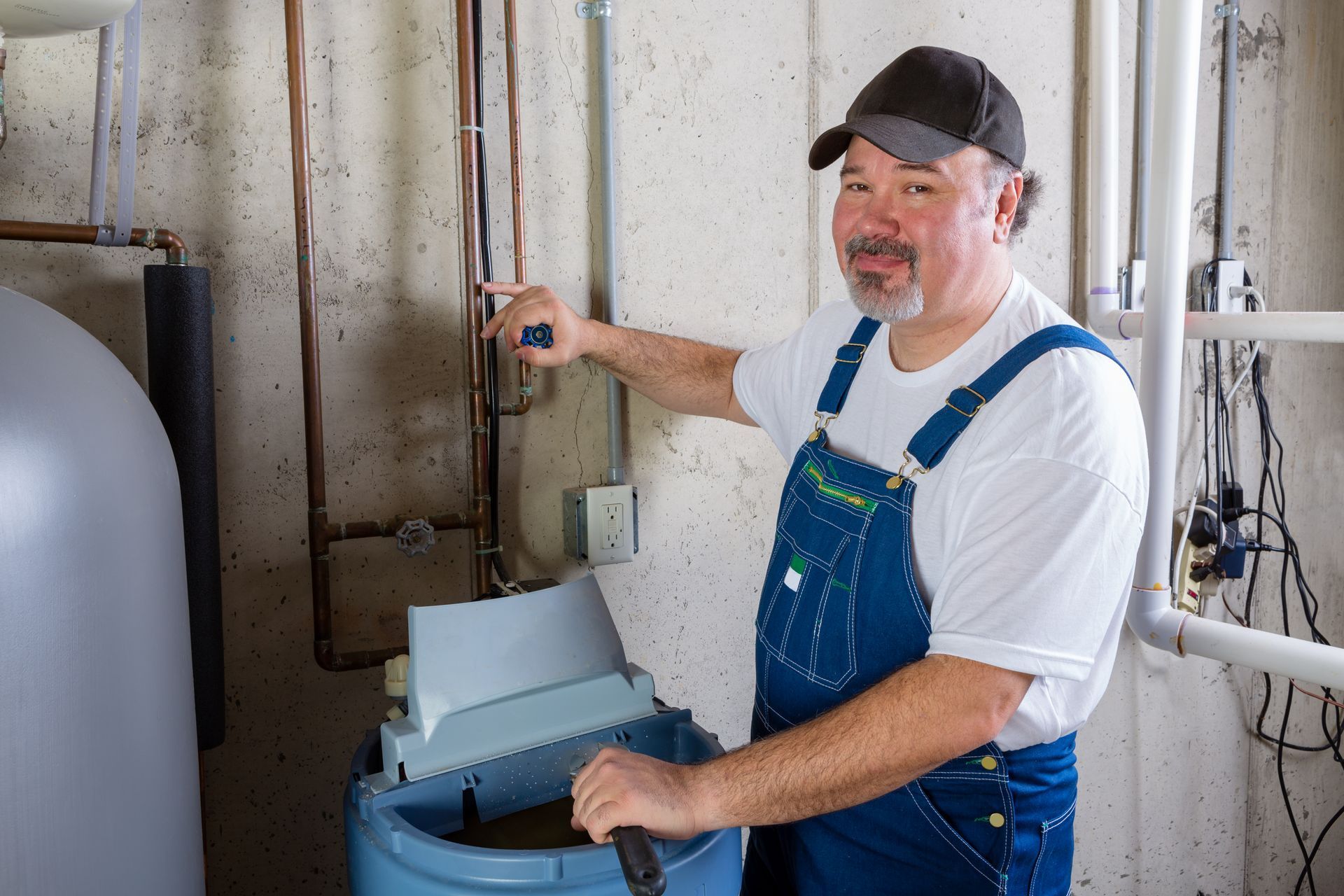 a plumbing technician installing a water softener into a home