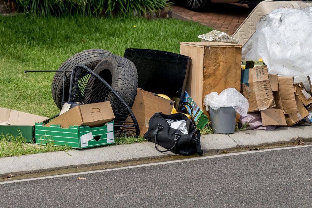 A pile of trash is sitting on the side of the road.