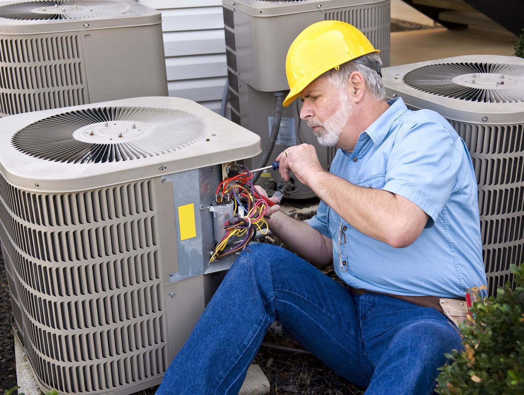 Technician repairing HVAC unit, he knowss how to extend the life of an HVAC system