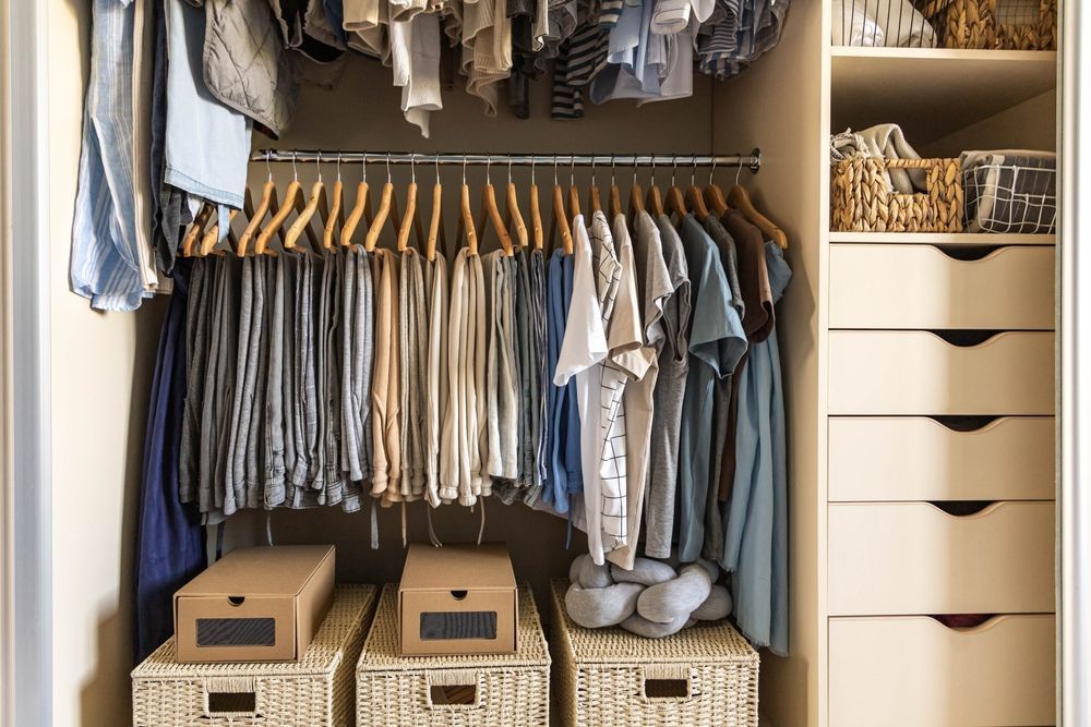 A closet filled with lots of clothes and baskets.