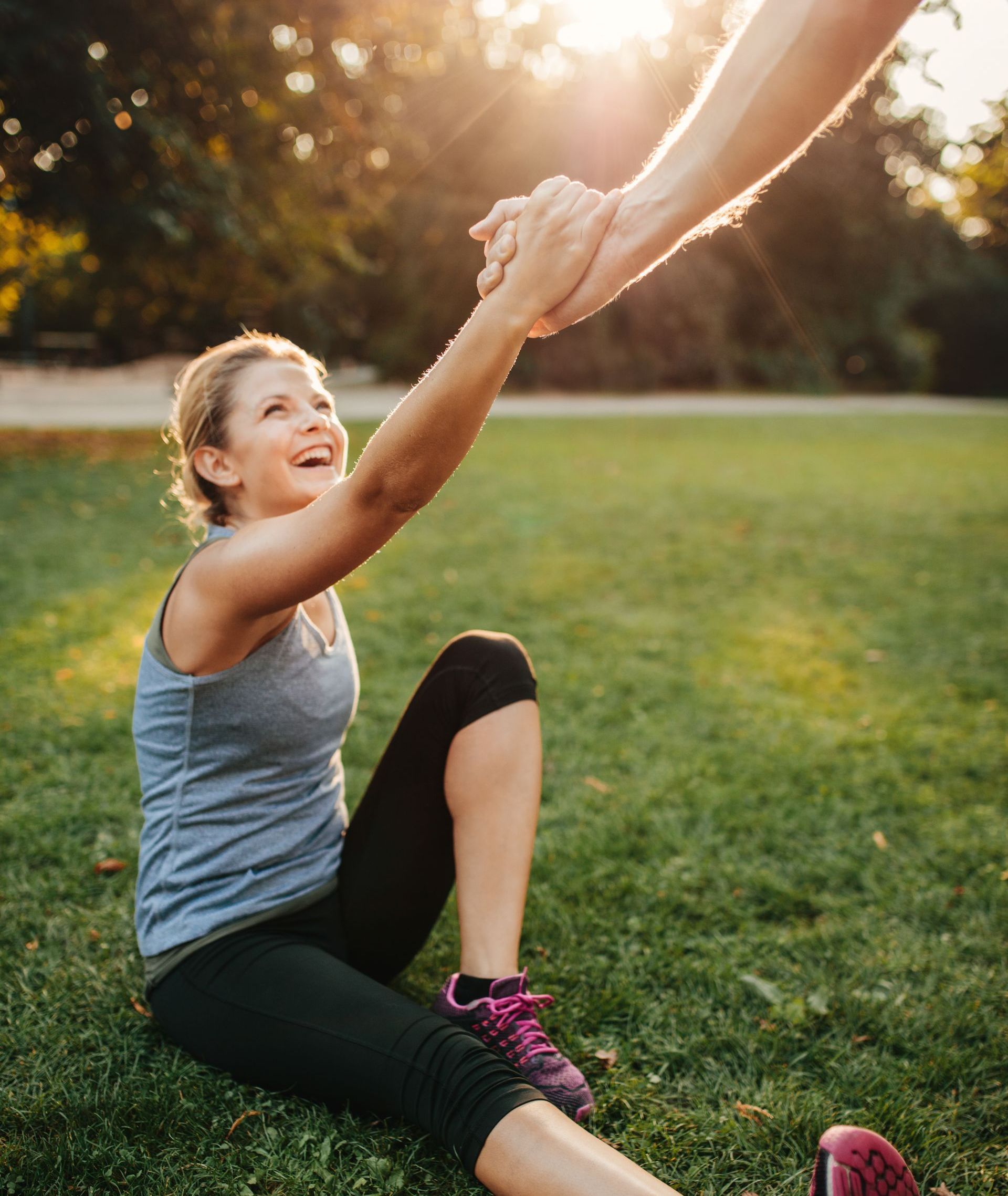 one of the workout partners gets a helping hand off the ground after stretching