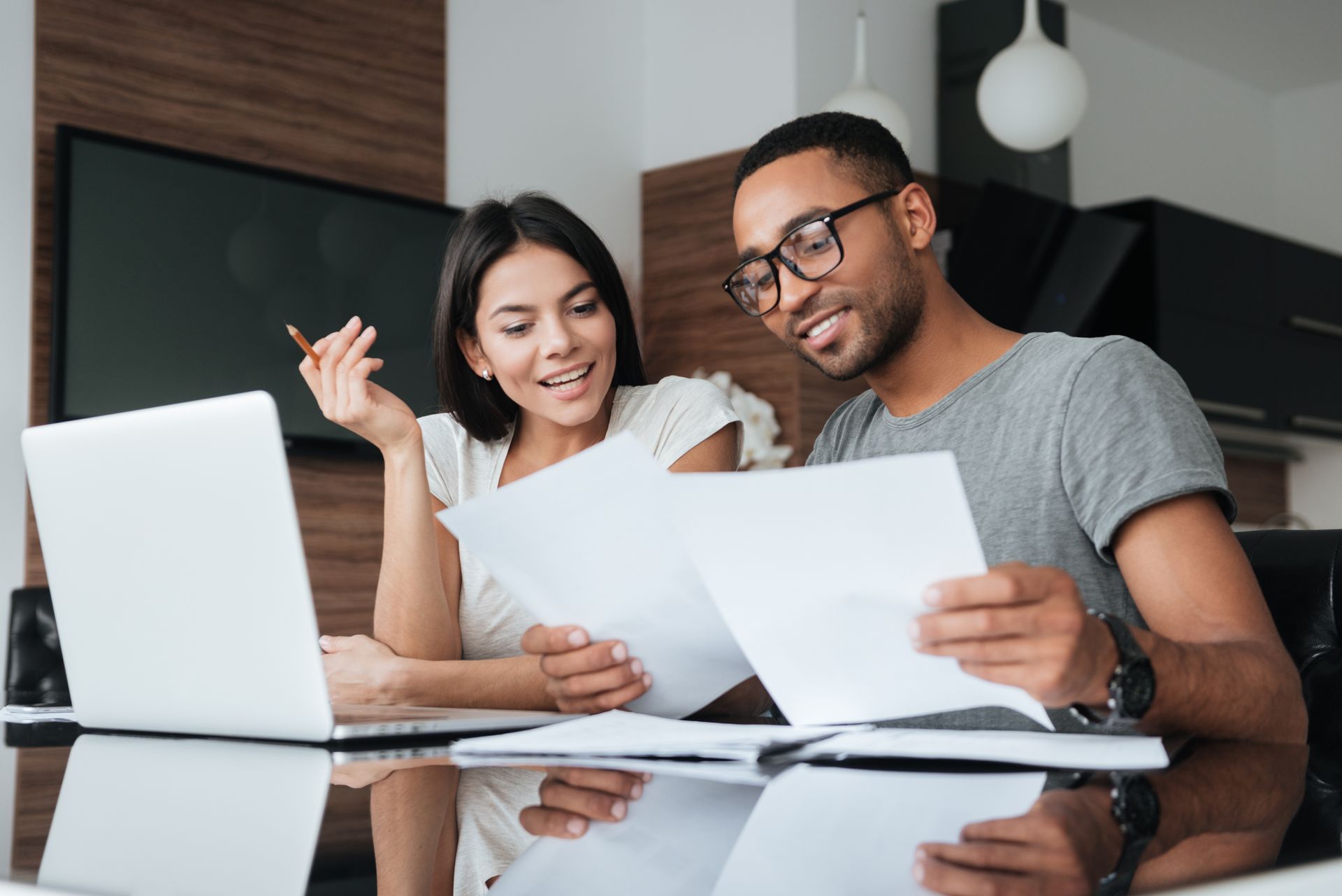 a man and a woman are sitting at a table creating a budget for the month.