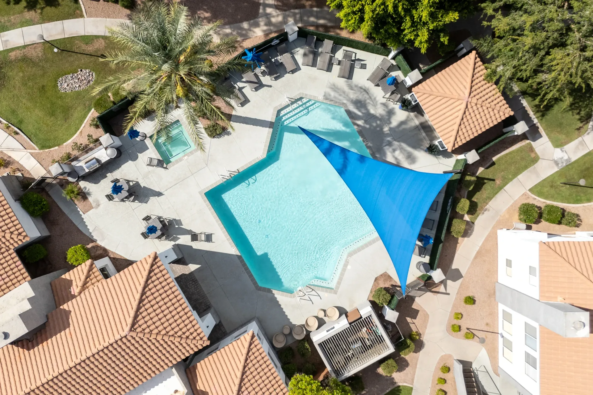 Aerial view of a resort-style swimming pool with lounge chairs and a spa.