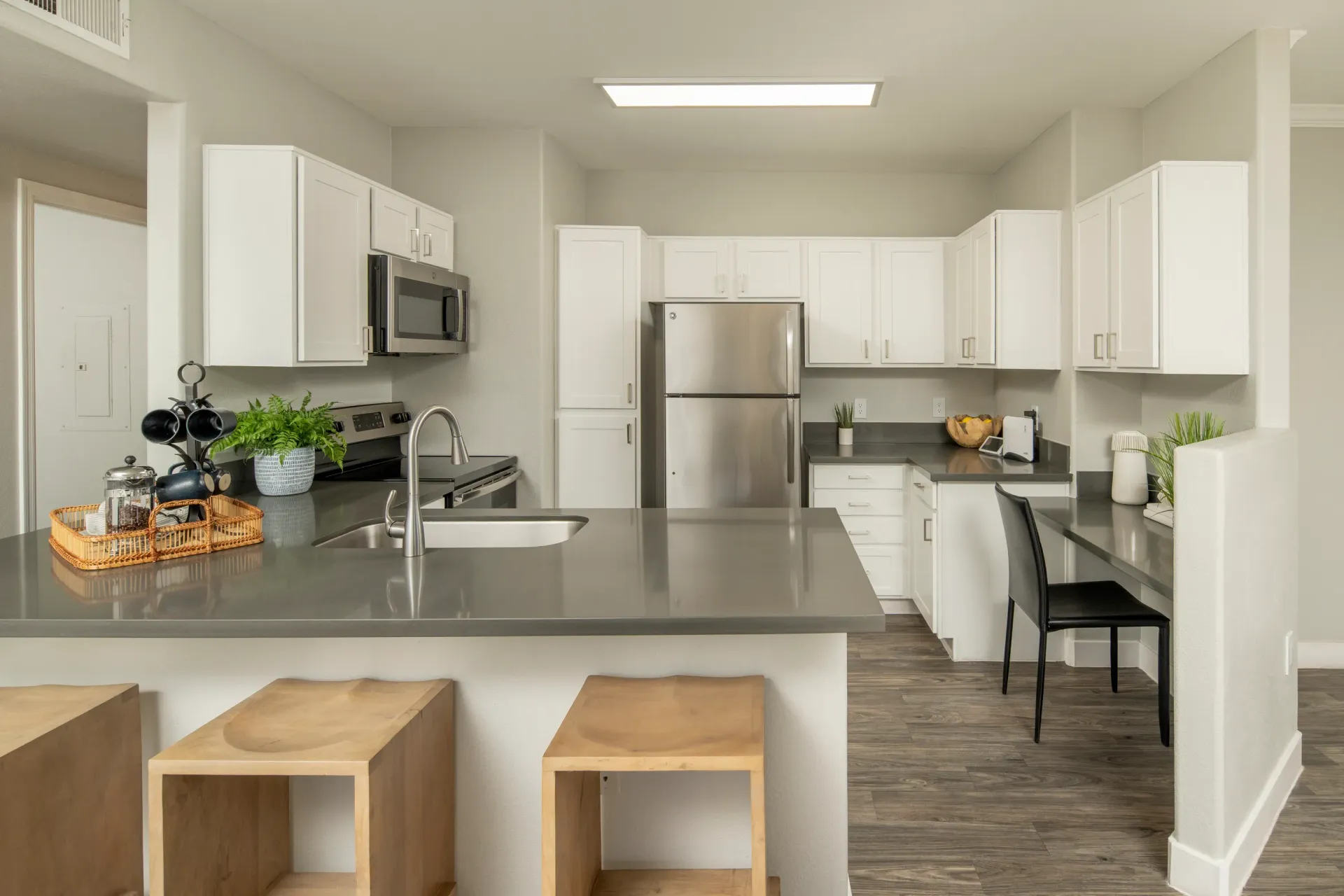 Modern kitchen with stainless steel appliances, white cabinets, and a large island.