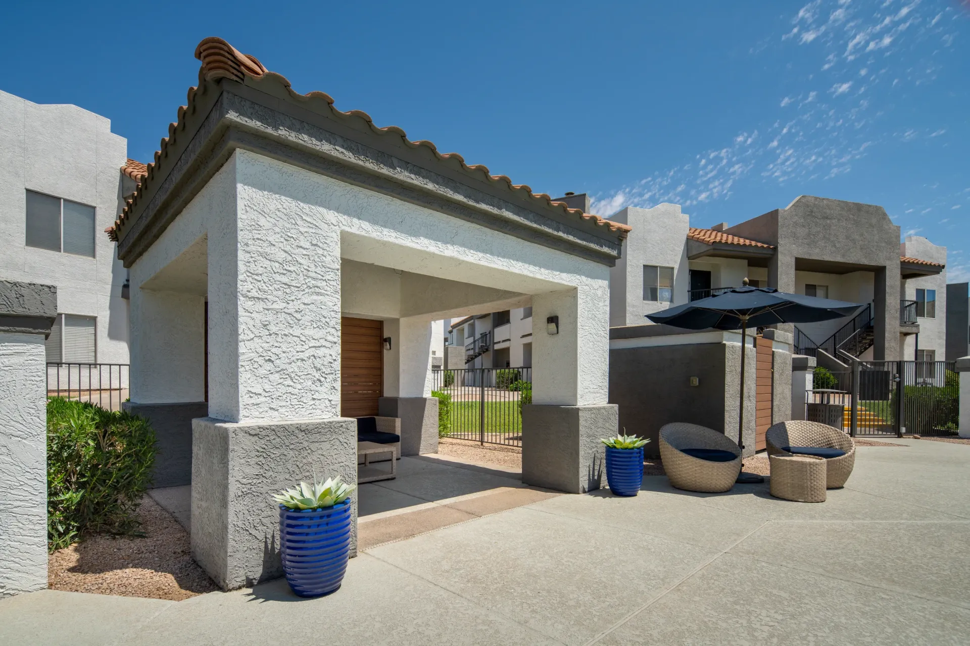 Covered patio area with seating and outdoor umbrella.