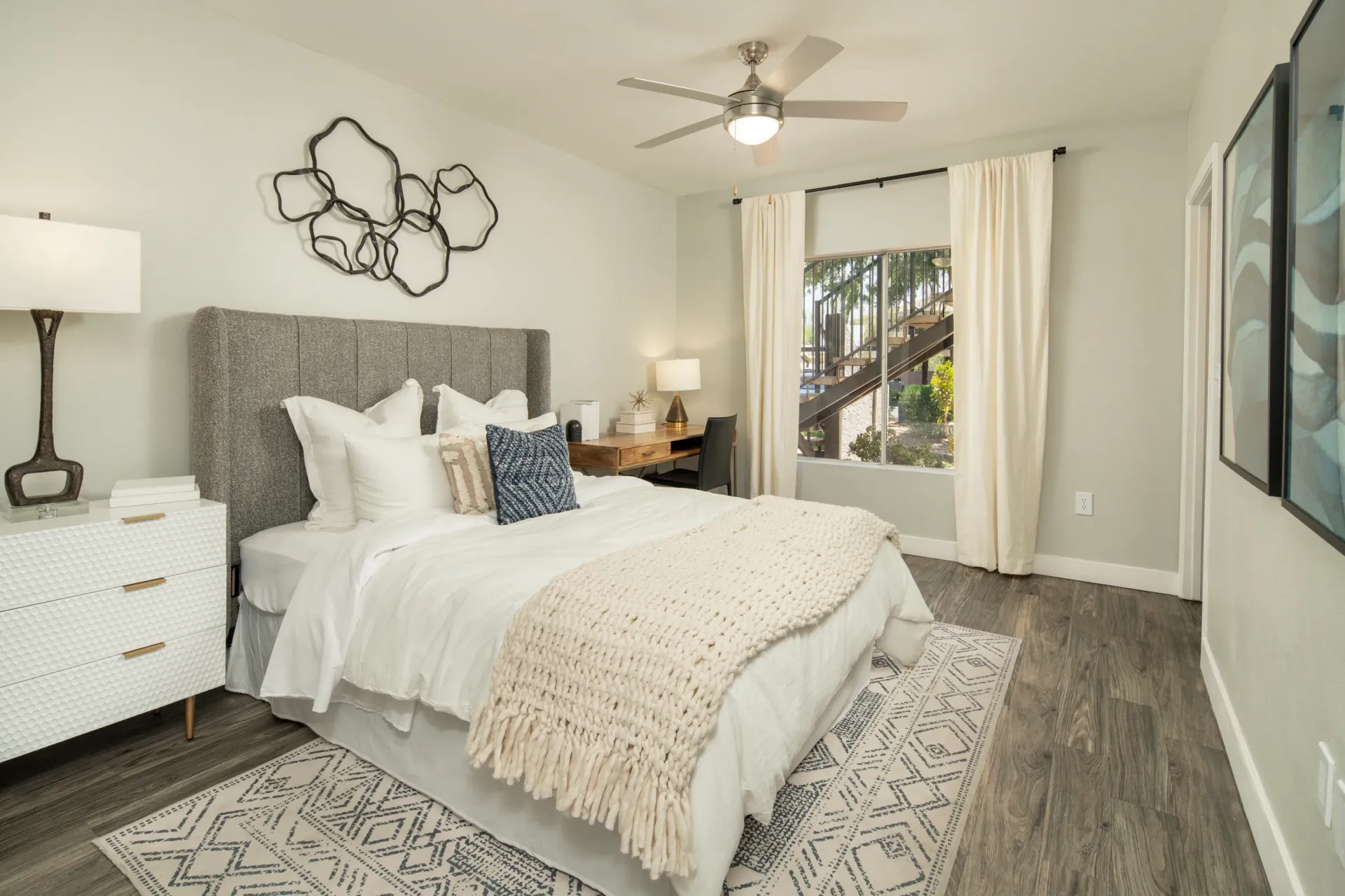 Bedroom with a king-size bed, nightstand, and desk with a chair.