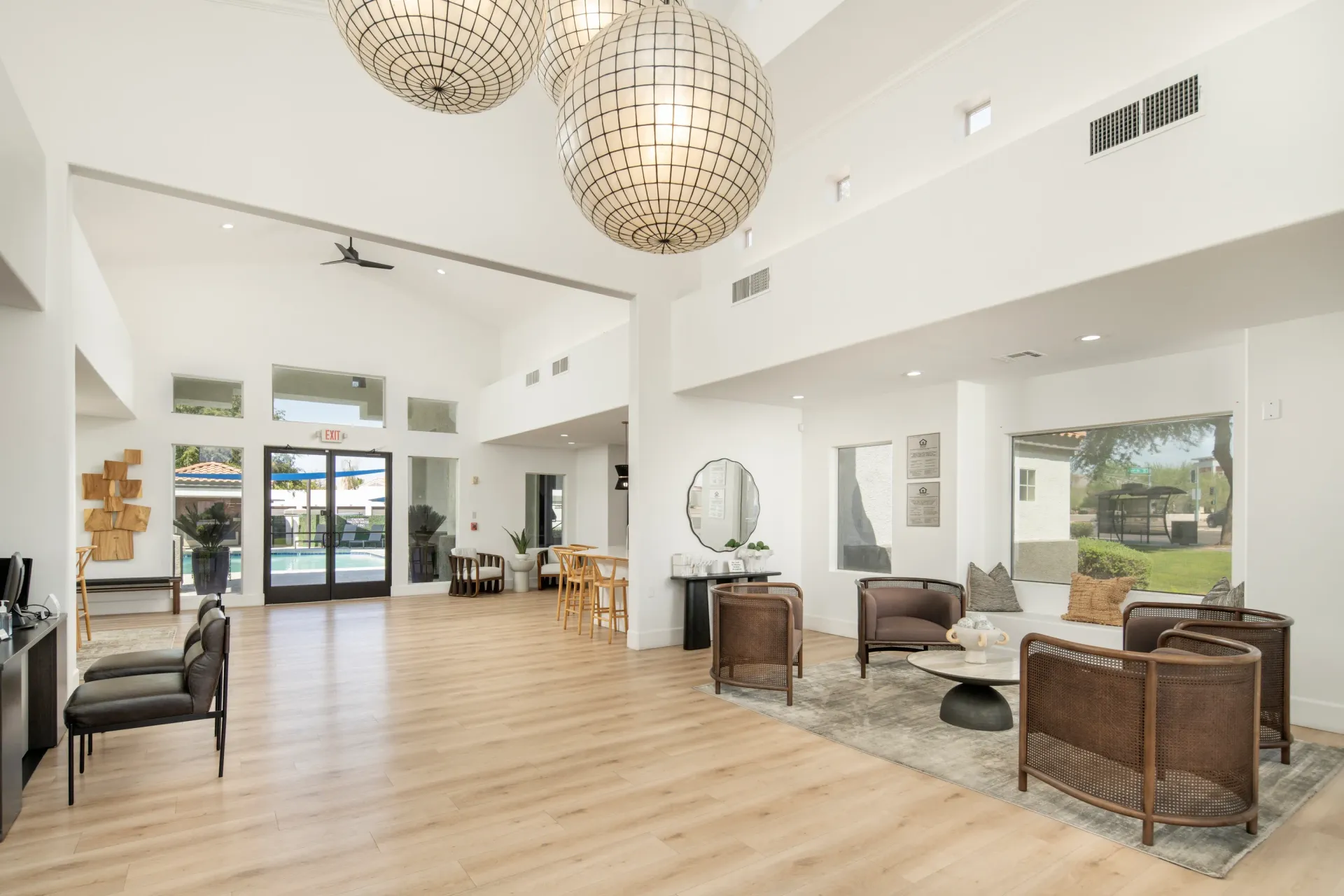Spacious, well-lit community lounge with modern furniture and large windows overlooking the pool area.