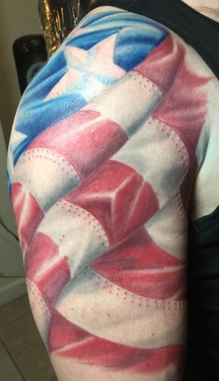 Tattoo of the American flag draped on a person's upper arm, with red and white stripes and a blue star field.