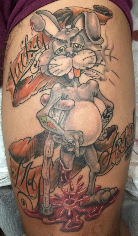 Tattoo of a skeletal, sad Bugs Bunny in a pool of blood, with scrolling banners.