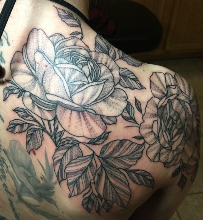 Black and white rose tattoo on a person's shoulder and upper arm.