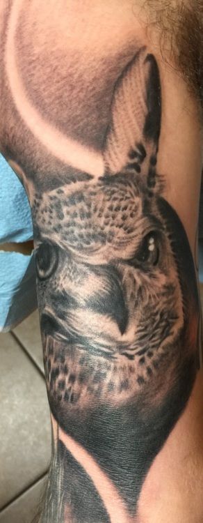 Black and gray tattoo of an alpaca's face on an arm.