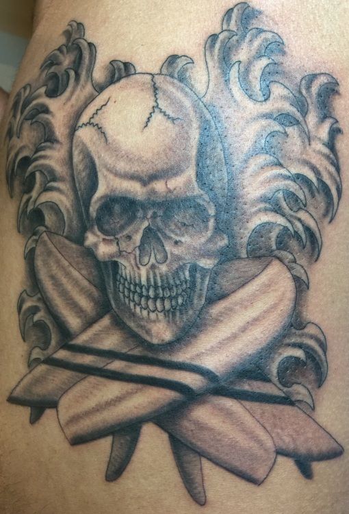 Skull tattoo with crossed swords and decorative scrollwork. Gray scale.