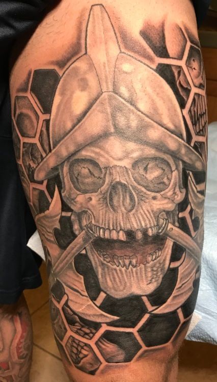 Tattoo of a skull wearing a conquistador helmet. Bone and honeycomb background.