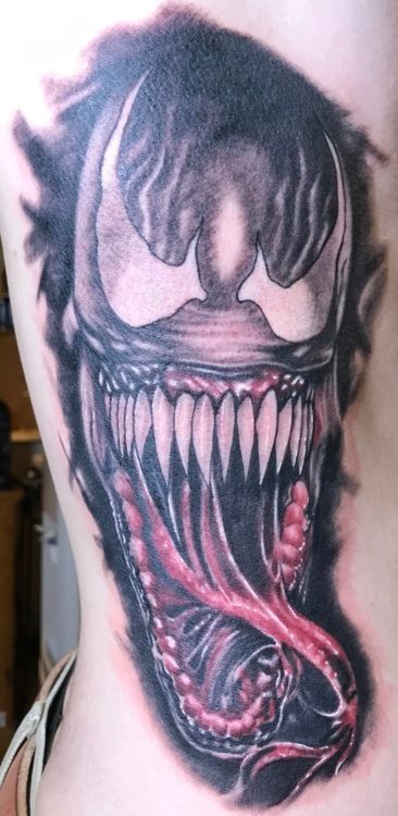 Venom tattoo on skin, black and white with red tongue, a comic book villain.