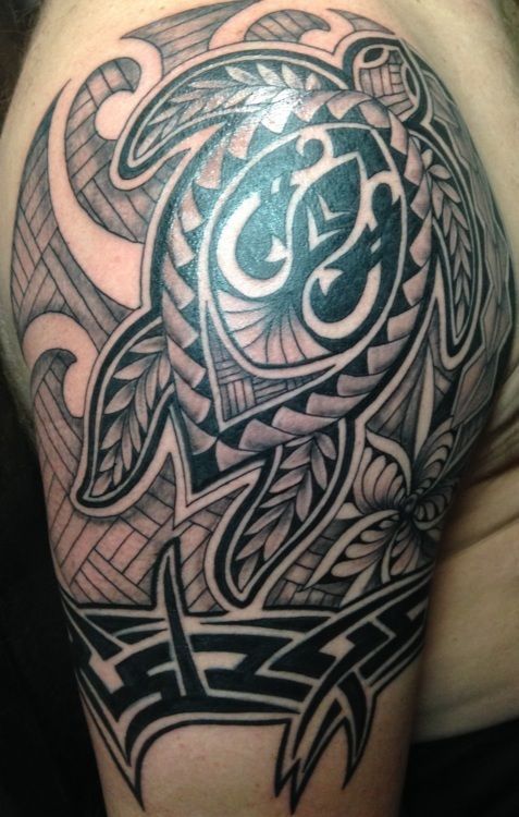 Tattoo of a sea turtle with tribal designs on a shoulder and upper arm. Black ink.
