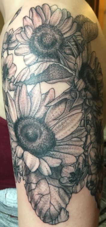 Tattoo of sunflowers on a person's arm. The tattoo is in black and white.