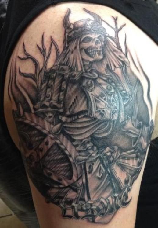Tattoo of a skeletal warrior in armor with a horned helmet, holding a shield.
