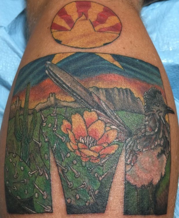 Tattoo of Arizona landscape with a cactus, bird, mountains, and 