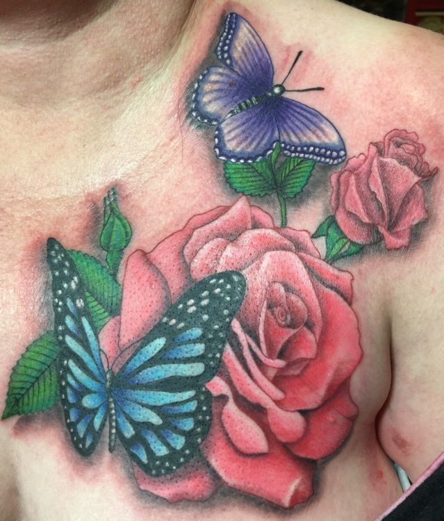Tattoo of two blue butterflies and pink roses on a person's chest.