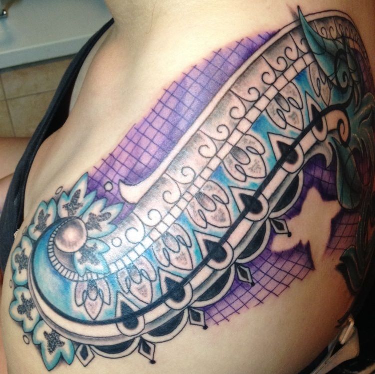 Colorful ornate tattoo on a person's chest, featuring blue, purple, and black patterns.