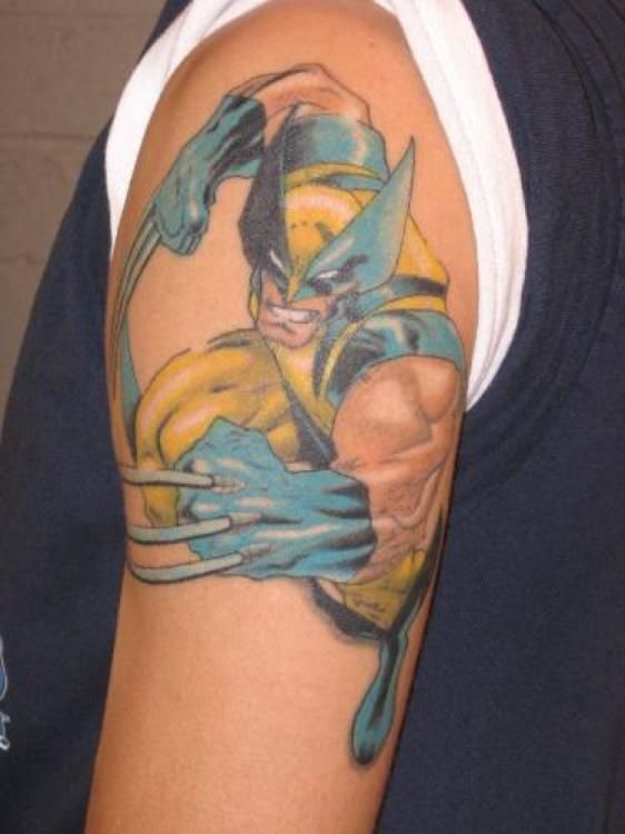 Wolverine tattoo on a person's upper arm, in yellow and blue, with claws extended, a grimace.