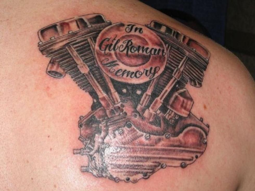 Tattoo of a motorcycle engine on a person's shoulder with the words 