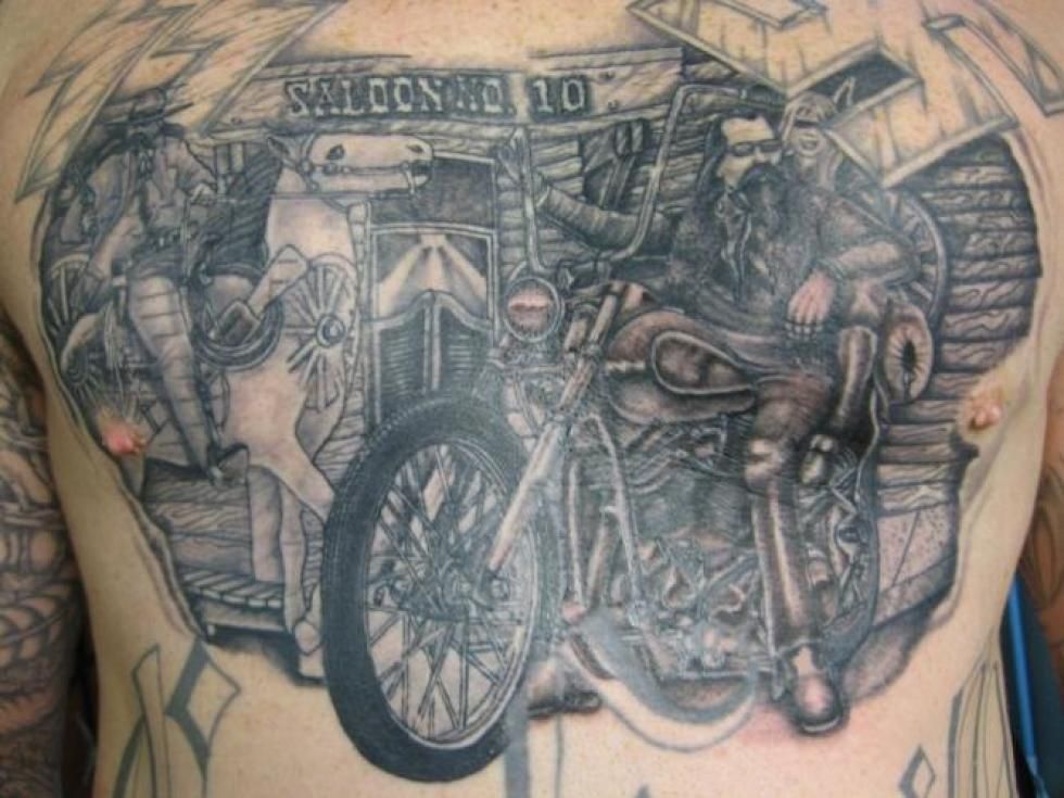 Tattoo: Man with long beard on motorcycle in front of Saloon No. 10; elephant and horse on left side.