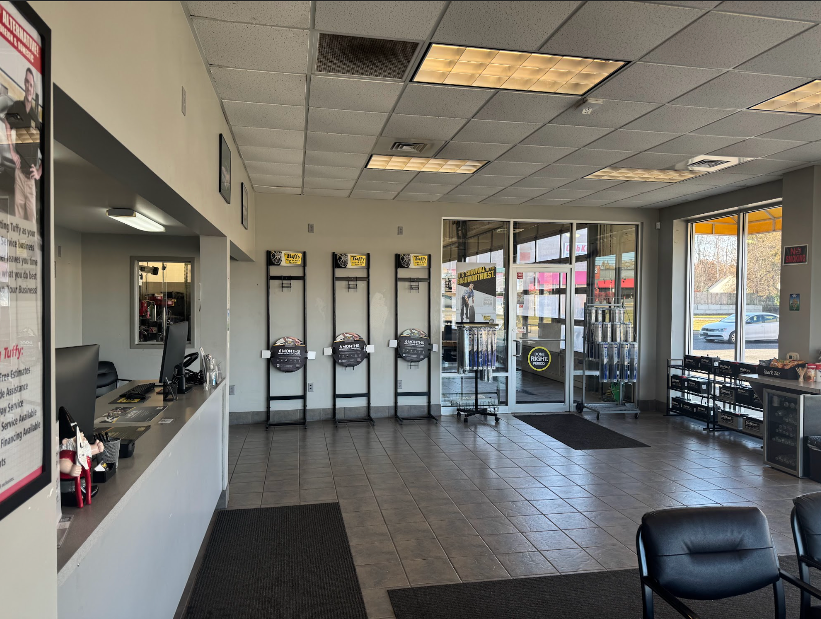 Interior of an auto repair shop waiting area with chairs, counters, and service bays visible.