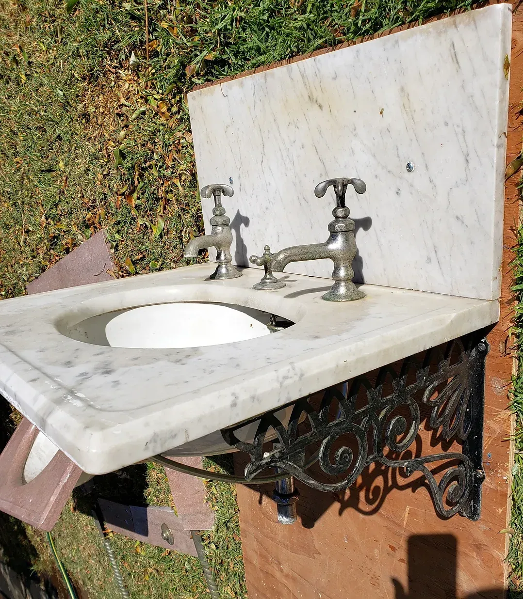 A marble sink with two faucets mounted to it