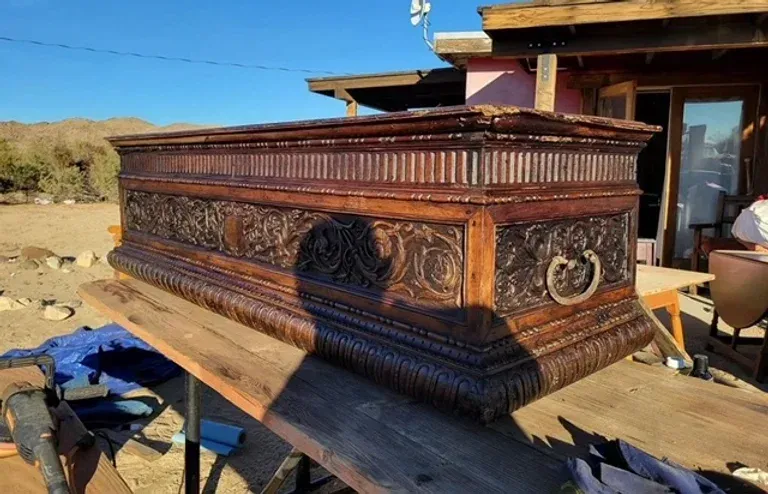 A large wooden box is sitting on top of a wooden table.