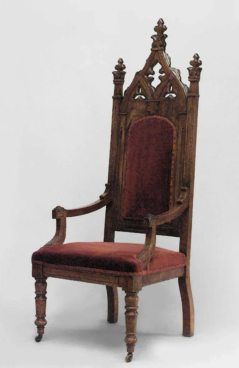 A wooden chair with a red cushion on a white background