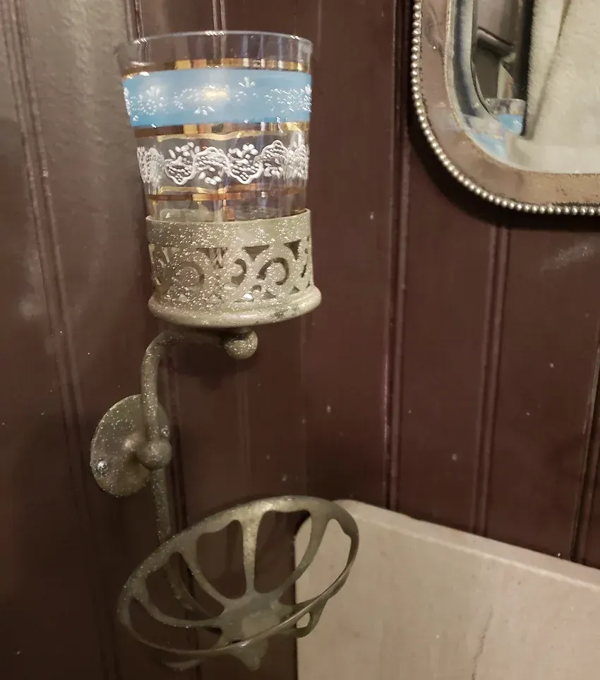 A bathroom with a soap dish and a glass holder