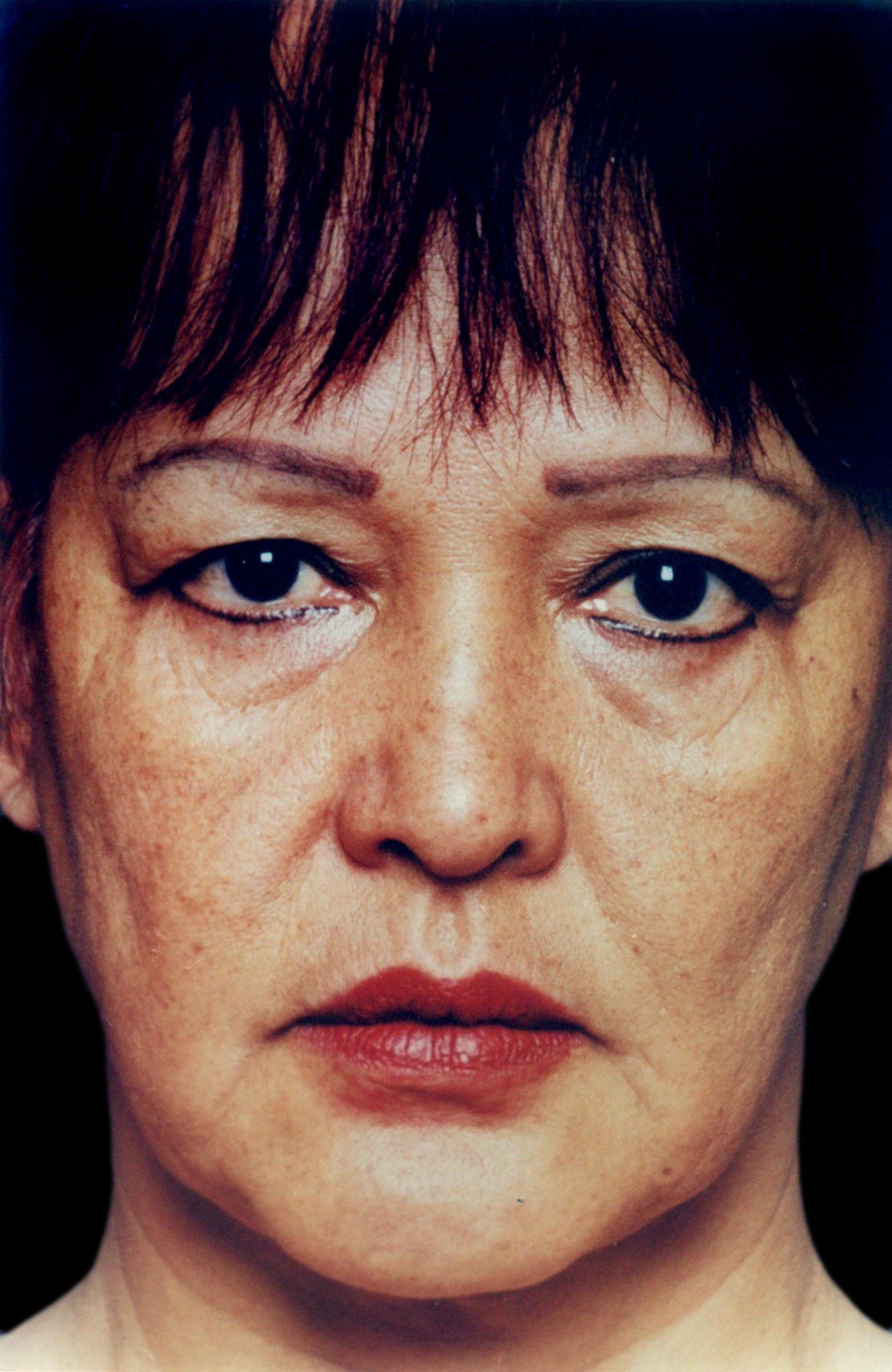 A close up of a woman 's face with a serious look on her face.