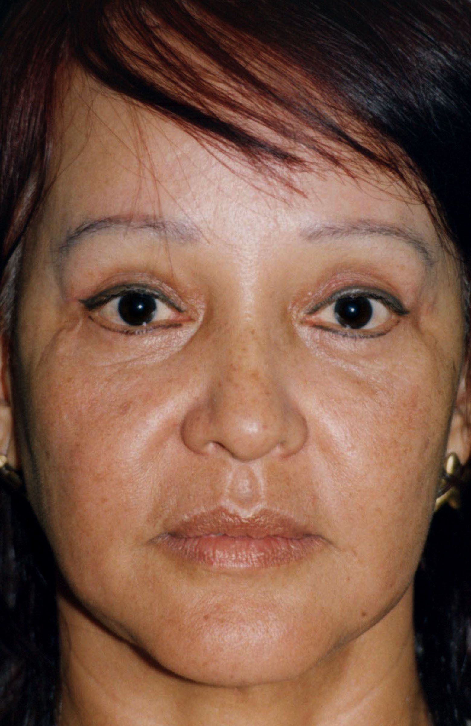 A close up of a woman 's face with a serious look on her face.
