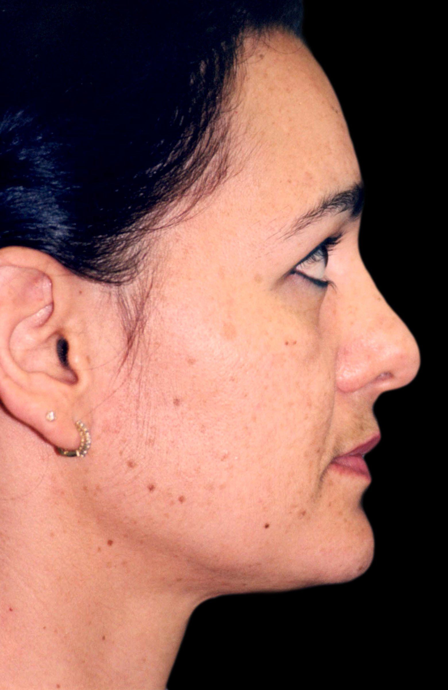 A close up of a woman 's face with a black background.