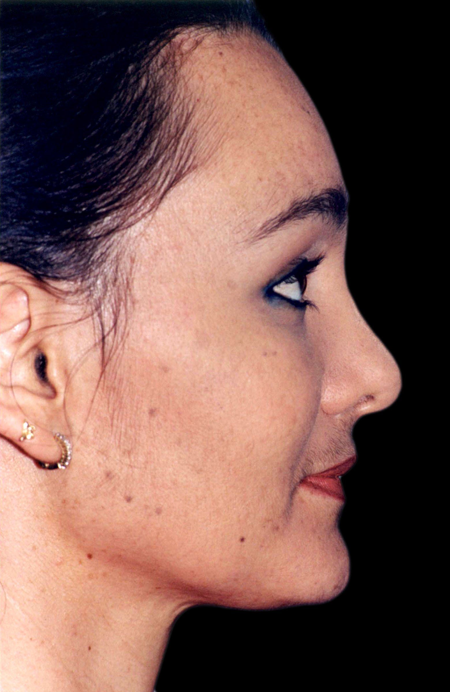 A close up of a woman 's face with a black background.