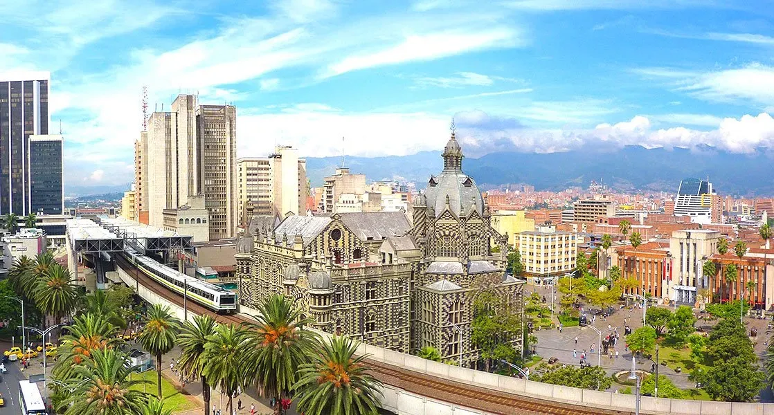 An aerial view of a city with a train going through it.