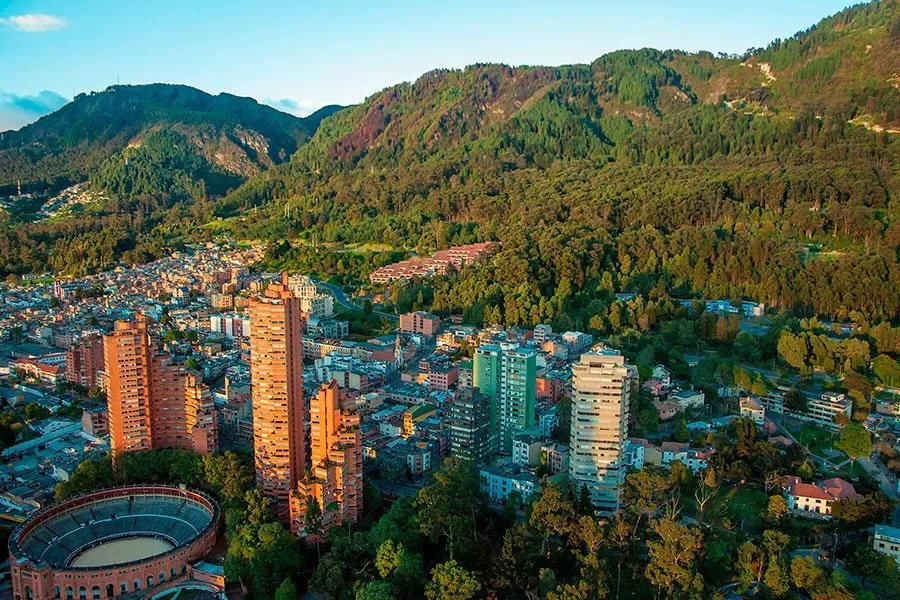 An aerial view of a city surrounded by mountains and trees.