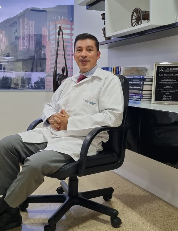 A man in a lab coat is sitting in a chair