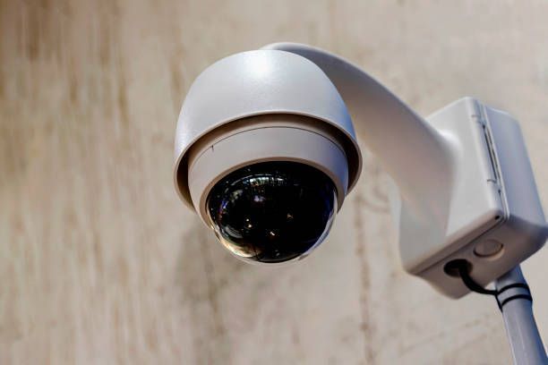 A close up of a security camera on a pole.