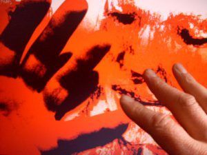 abstraktes Foto mit rotem Untergrund und drei Finger einer Hand