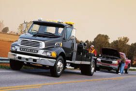 Burnaby Towing providing roadside assistance to a broken down red truck.