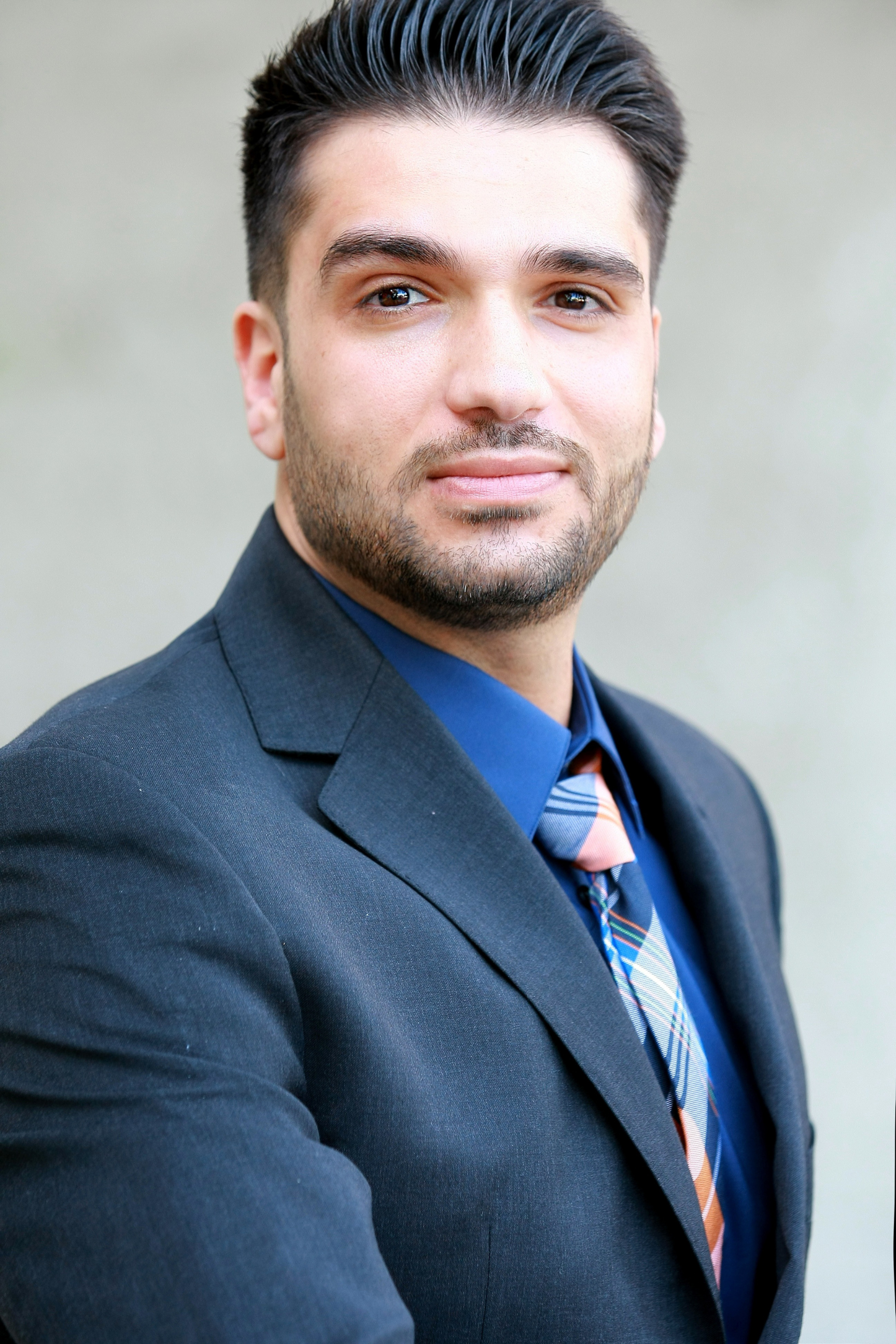 A man in a suit and tie is smiling for the camera