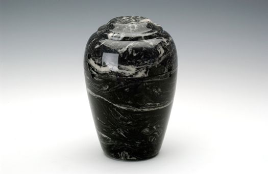 Black polished stone urn with white veining on a plain white background