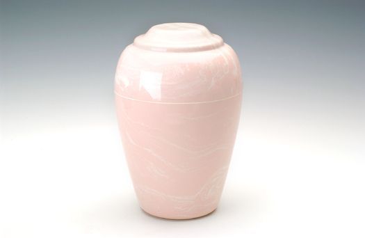 Pale pink ceramic urn with lid on a white background